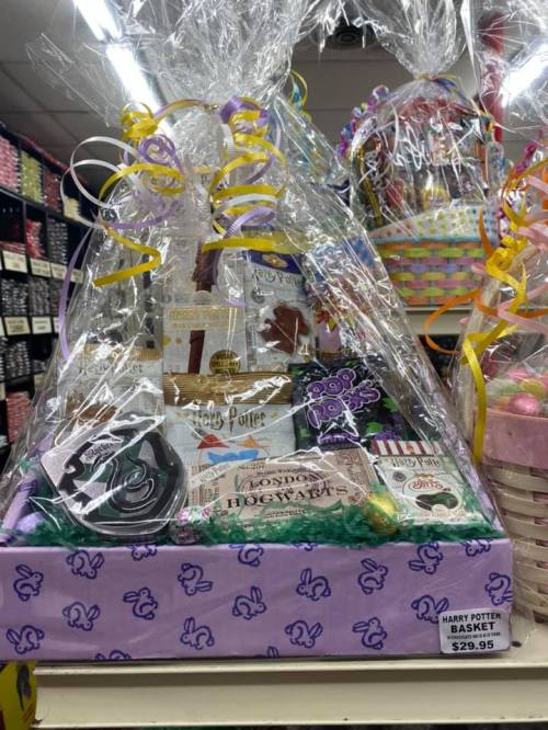 A Harry Potter-themed gift basket filled with snacks and treats, wrapped in clear cellophane and decorated with colorful ribbons.