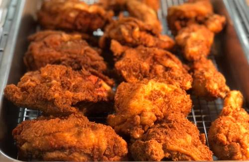 A tray of golden-brown, crispy fried chicken pieces arranged neatly.