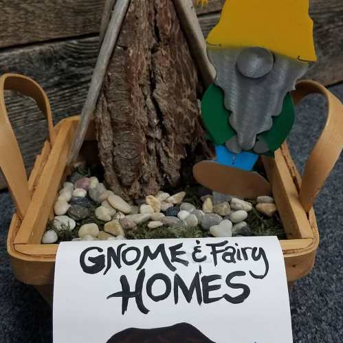 A decorative basket with a gnome figure, a wooden structure, and pebbles, labeled "Gnome & Fairy Homes."