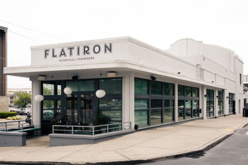 Exterior of Flatiron restaurant in Nashville, Tennessee, featuring large windows and a modern design.