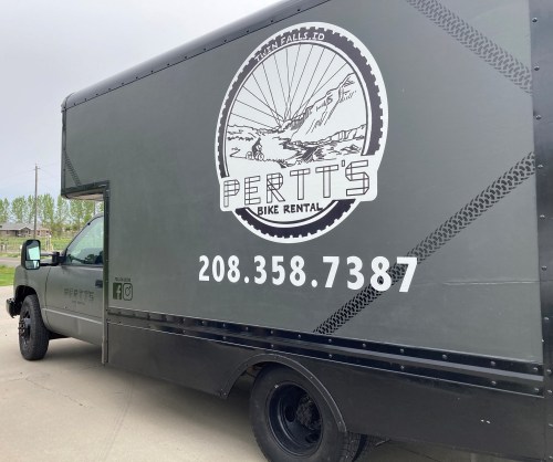A black truck with "PERTT'S BIKE RENTAL" logo and contact number 208.358.7387 displayed on the side.