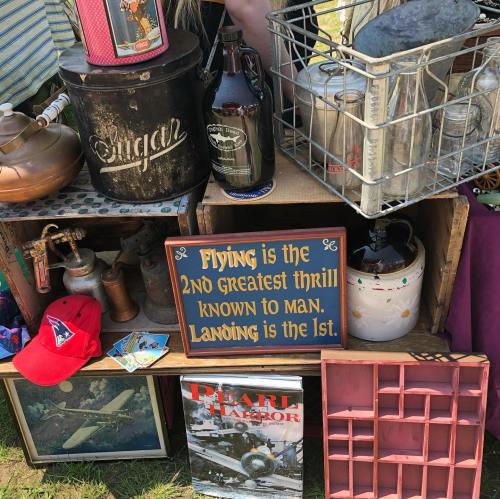A display of vintage items, including a sign that reads, "Flying is the 2nd greatest thrill known to man. Landing is the 1st."