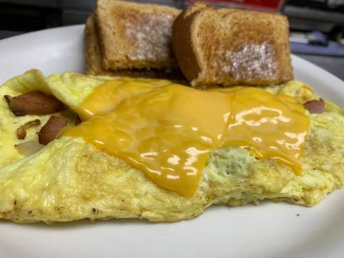 A plate with a cheesy omelette and two slices of toasted bread.