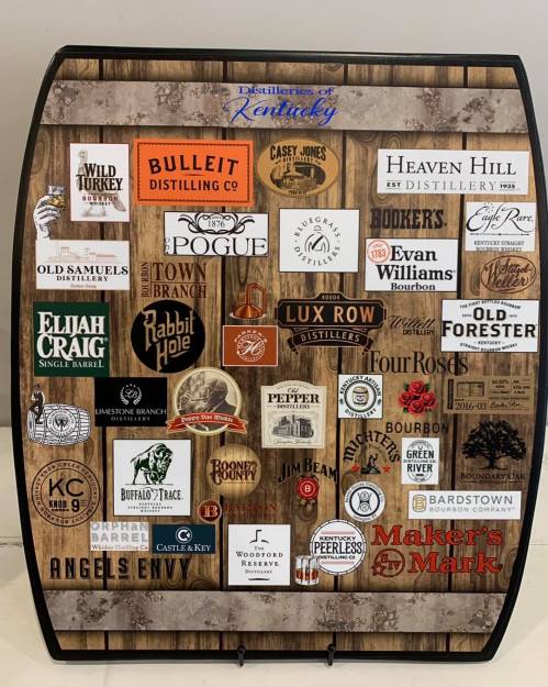 A wooden barrel display featuring various logos of Kentucky distilleries and whiskey brands.