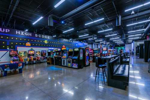 A vibrant arcade filled with classic pinball machines and video game cabinets, illuminated by colorful lights.