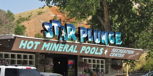 Sign for Star Plunge Hot Mineral Pools Recreation Center, featuring bright blue letters and a welcoming entrance.