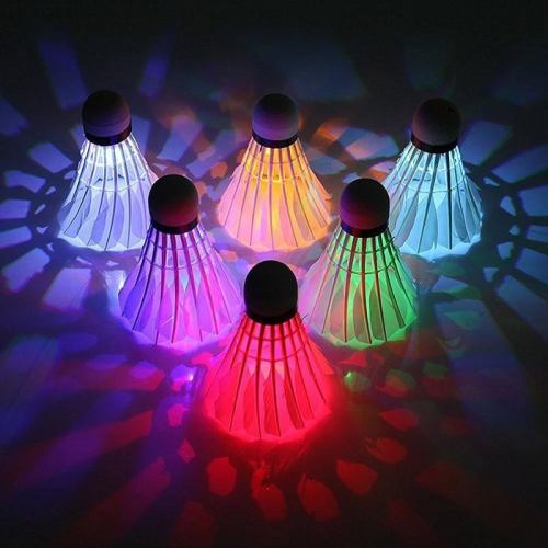 Colorful illuminated shuttlecocks arranged in a circle, casting vibrant light patterns on a surface.