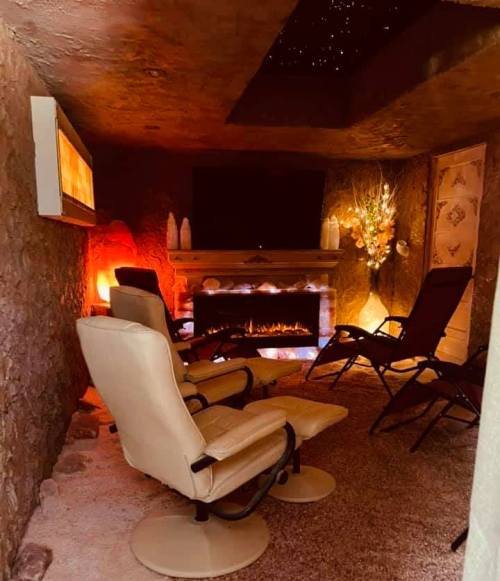 Cozy relaxation room with reclining chairs, a fireplace, and soft lighting, creating a warm, inviting atmosphere.