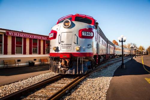 A vintage train, numbered 1940, parked at a station with a sign reading "My Old Kentucky Dinner Train."