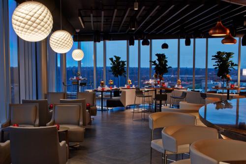 Modern restaurant interior with elegant lighting, stylish furniture, and large windows showcasing a twilight view.