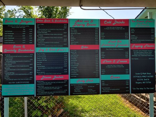 Menu board featuring burgers, sandwiches, drinks, and desserts with prices listed for each item.