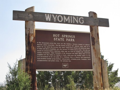 Sign for Hot Springs State Park in Wyoming, detailing park features and visitor information. Natural scenery in the background.