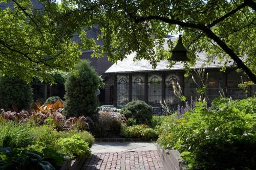 A lush garden with vibrant flowers and greenery, leading to a charming glass-enclosed building.