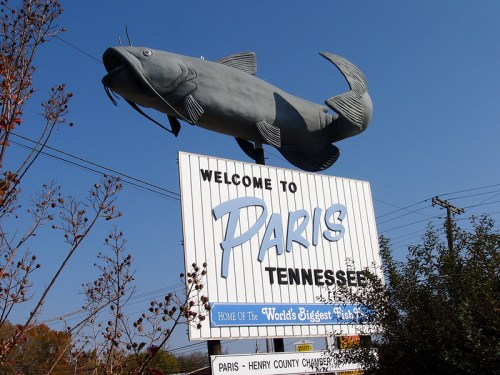 A large catfish statue atop a sign welcoming visitors to Paris, Tennessee, home of the World's Biggest Fish.