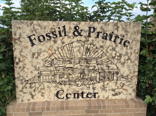 Sign for the Fossil & Prairie Center featuring a fossil design and the center's name prominently displayed.