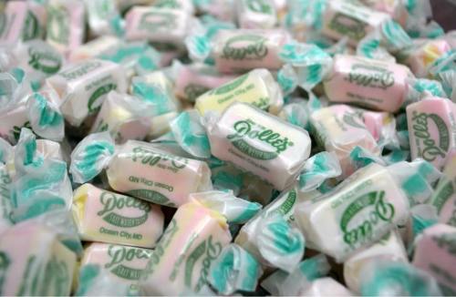 A close-up of colorful wrapped candies with "Dolle's" branding, scattered in a pile.