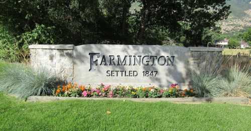 Sign reading "Farmington Settled 1847" surrounded by flowers and greenery.