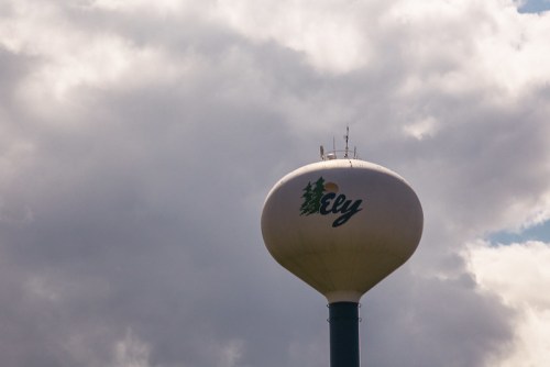 Water tower with "Ely" written on it, set against a cloudy sky.