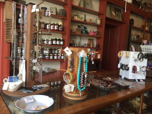 A display of various jewelry pieces in a quaint shop, with necklaces, bracelets, and accessories on wooden stands.