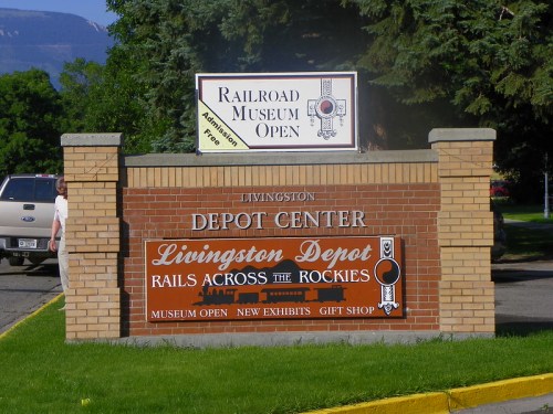 Sign for the Livingston Depot Center, featuring "Railroad Museum Open" and details about exhibits and a gift shop.