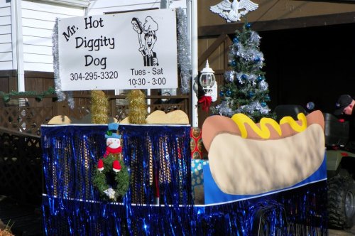 A festive hot dog cart decorated with tinsel, a sign for "Mr. Hot Diggity Dog," and a small Christmas tree.