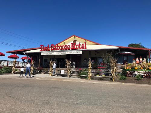 Exterior of the Red Goose Motel featuring a restaurant, gift shop, and ice cream stand, with colorful umbrellas and decorations.