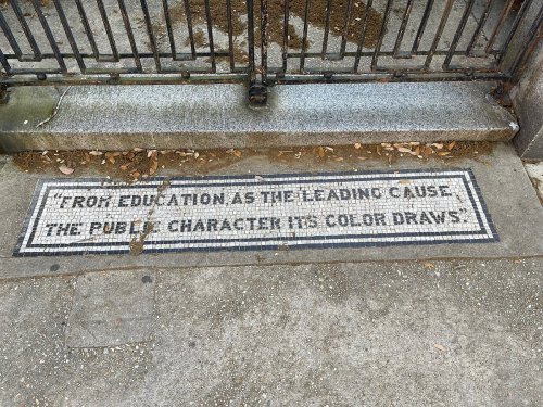 Mosaic inscription on pavement reads: "From education as the leading cause, the public character the color draws."