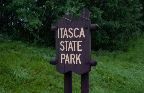 Sign for Itasca State Park surrounded by greenery.