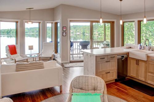 Bright, modern kitchen with lake view, featuring a cozy living area and large windows.