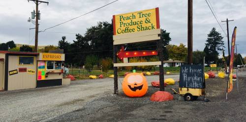 Sign for Peach Tree Produce & Coffee Shack with a pumpkin decoration and a chalkboard advertising pumpkin lattes.