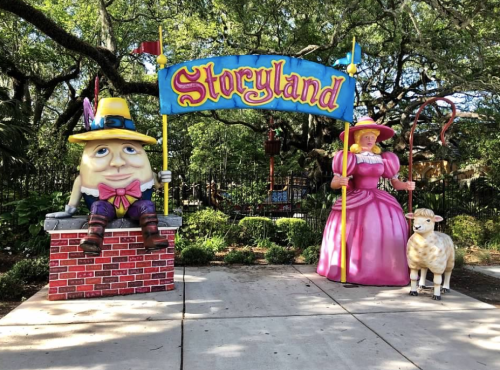 Colorful entrance to Storyland featuring Humpty Dumpty, a princess, and a sheep under a vibrant sign.