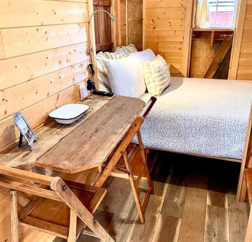 Cozy wooden bedroom with a bed, rustic desk, and warm lighting, featuring a minimalist design and natural materials.