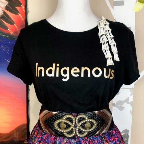 A black t-shirt with the word "Indigenous" in gold, paired with a colorful skirt and a decorative belt.