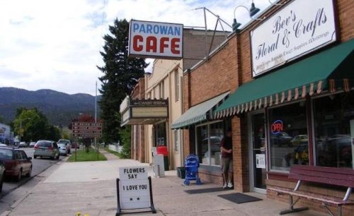 A street view featuring Parowan Cafe and a flower shop, with a sign saying "Flowers say I love you." Mountains in the background.