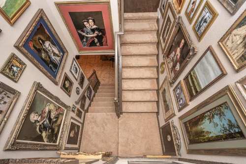 A staircase with a gallery of framed paintings lining the walls, creating an artistic and inviting atmosphere.