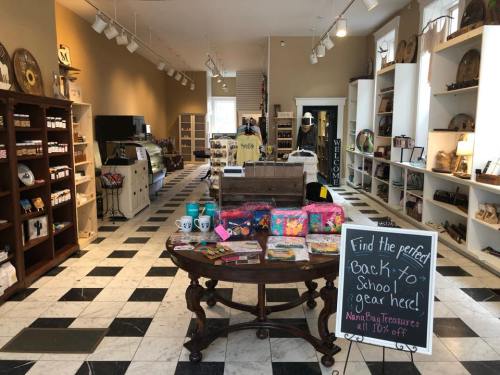 A cozy store interior with a central table displaying colorful items and a sign promoting back-to-school gear.