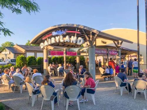 A busy ice cream shop called Dairyland, with people enjoying treats outside on a sunny day.