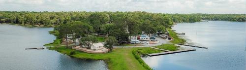 Aerial view of a lakeside area with trees, a small community, and docks along the water's edge.