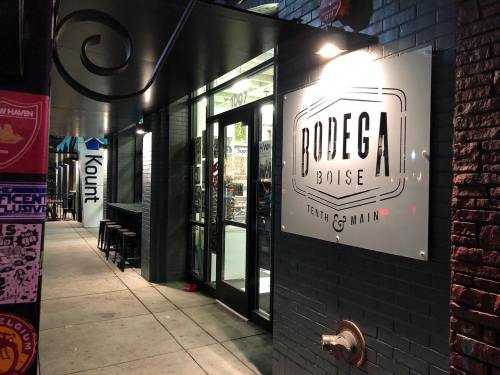 Sign for Bodega Boise at Tenth & Main, with a storefront visible at night.