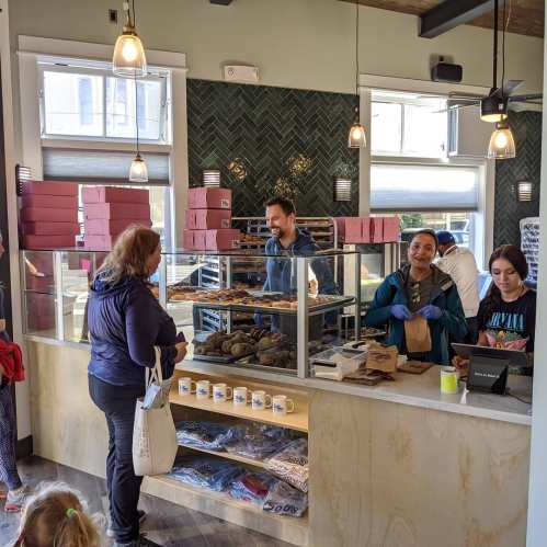 A bakery interior with a counter, staff serving customers, and baked goods displayed in a bright, welcoming space.