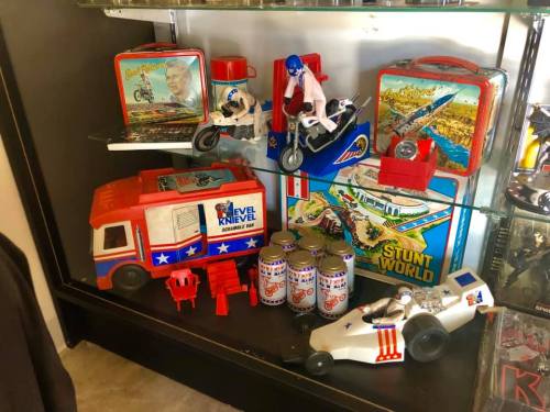A display case filled with vintage Evel Knievel toys, lunchboxes, and stunt-themed memorabilia.