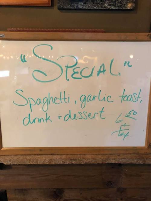 Whiteboard sign advertising a special: spaghetti, garlic toast, drink, and dessert for $6.50.