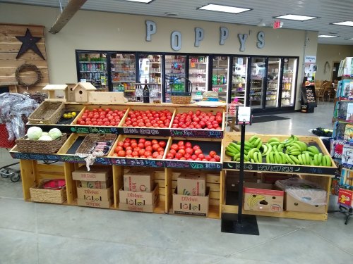 A colorful display of fresh produce, including tomatoes, melons, and bananas, in a market setting.