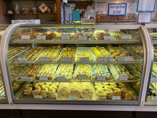 A display case filled with a variety of baked goods, including pastries, cookies, and breads.