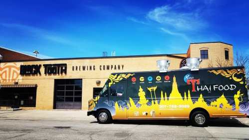 A colorful Thai food truck parked outside Black Tooth Brewing Company.
