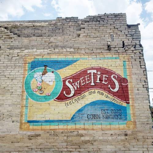 Colorful mural on a brick wall featuring "Sweeties" ice cream and mini doughnuts, established 2020 in Corbin, Kentucky.