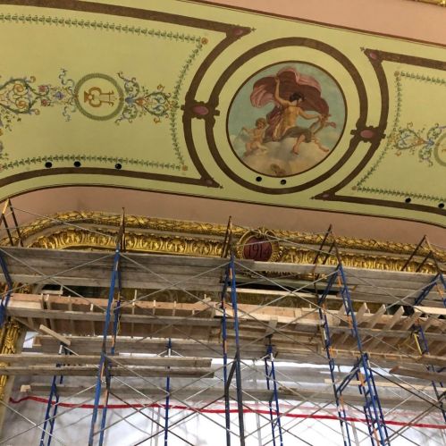 Scaffolding in front of ornate ceiling with a painted scene and decorative gold trim. Year "1912" visible.