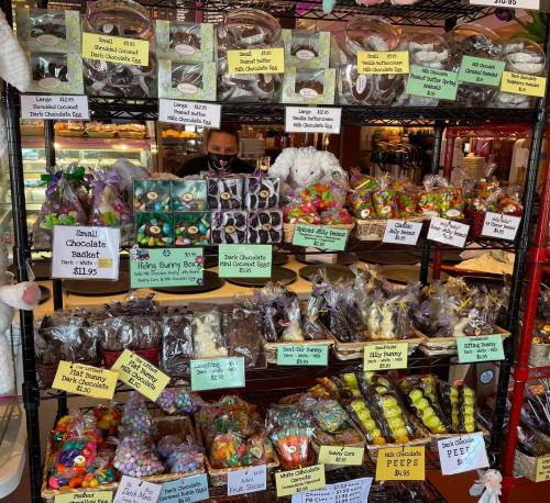 A display of colorful Easter treats, including chocolate bunnies, candy eggs, and festive baskets, with price tags.