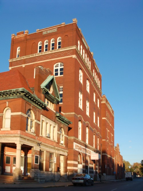 Historic red brick building with multiple stories and large windows, featuring a sign that reads "Brewhouse."