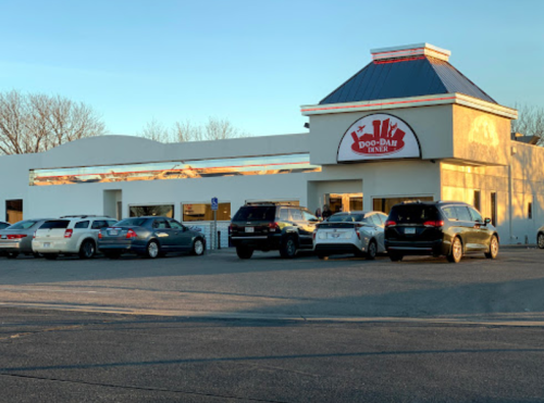 Exterior of Doo-Dad Diner with cars parked outside and a clear sky in the background.